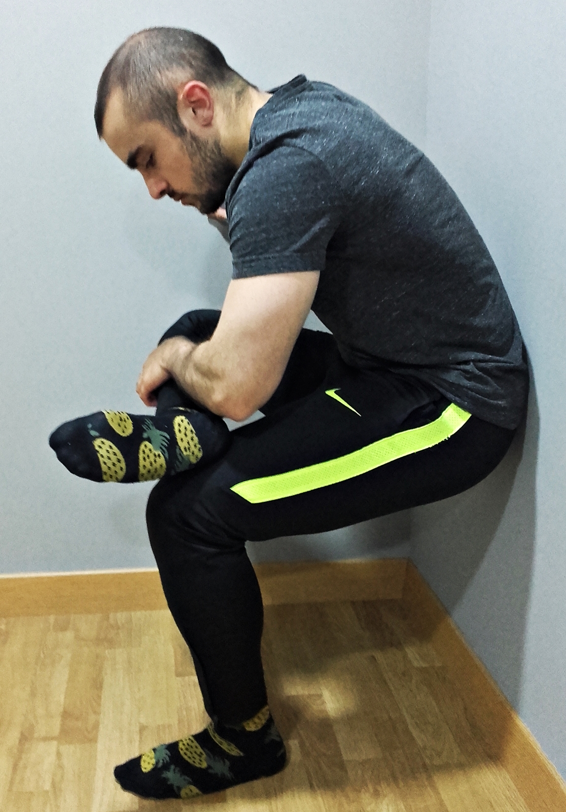 Otra variante de este estiramiento se puede realizar sentado o soportando nuestro propio peso. Se coloca el talón de la pierna del lado a estirar sobre la rodilla del lado contrario. Desde esta posición, y a la vez que se intenta mantener la espalda recta, aproximamos el tronco hacia la pierna cruzada, hasta sentir tensión en la parte superior del glúteo del lado estirado. Para mantener la espalda recta podemos pensar en “sacar culo” mientras descendemos el tronco.